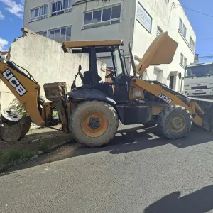 Retroescavadeira dispara e atinge muro de imóvel