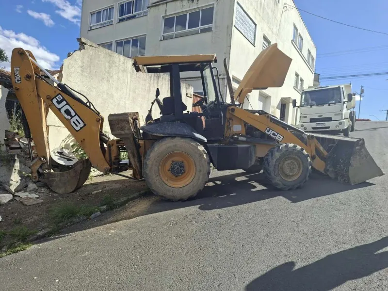 Retroescavadeira dispara e atinge muro de imóvel