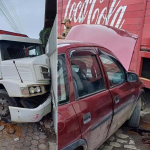 Caminhão perde freio, atravessa preferencial, bate em placas, carro e muro